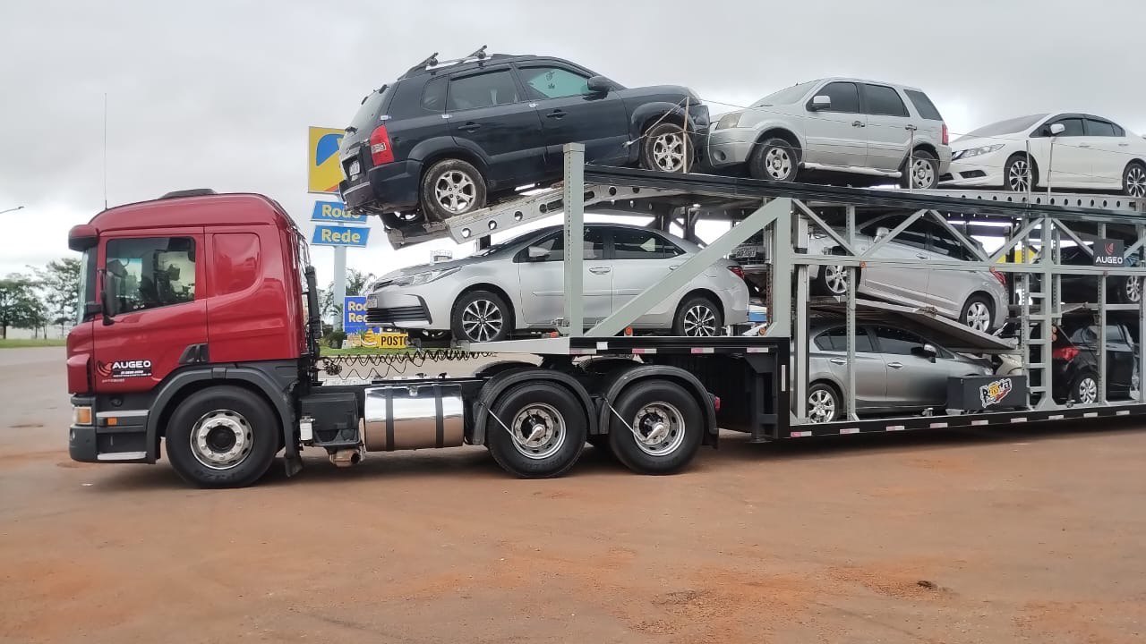 Caminhão da Augeo Transportes com carreta cegonha carregada de veículos, em parada rodoviária, rumo à COP30 em Belém