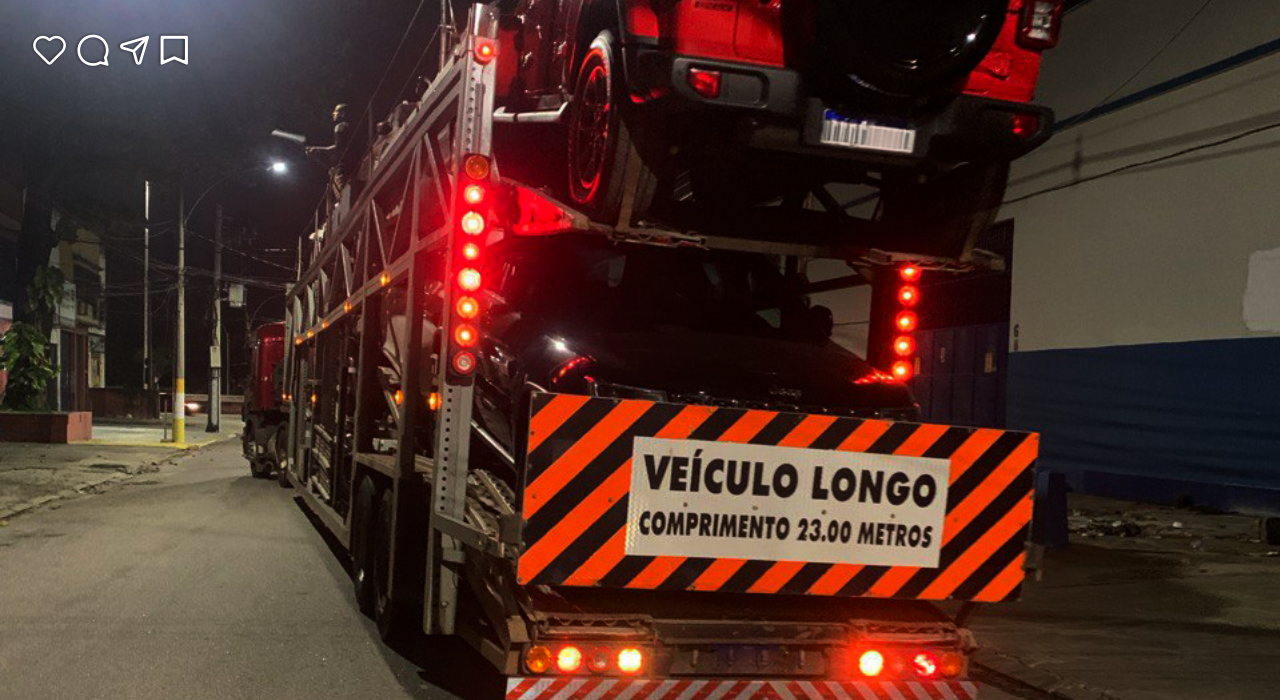 Caminhão cegonha transportando veículos em rodovia — Augeo Transportes